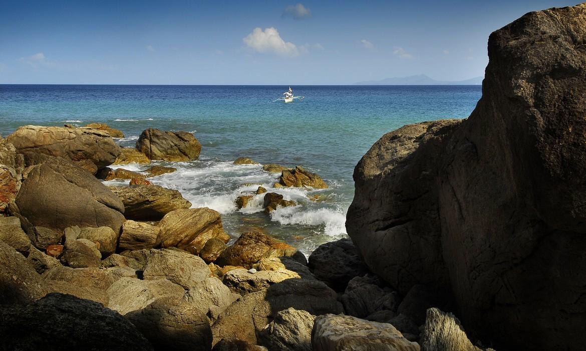 A tiny boat moving towards the shores of Puerto Galera 