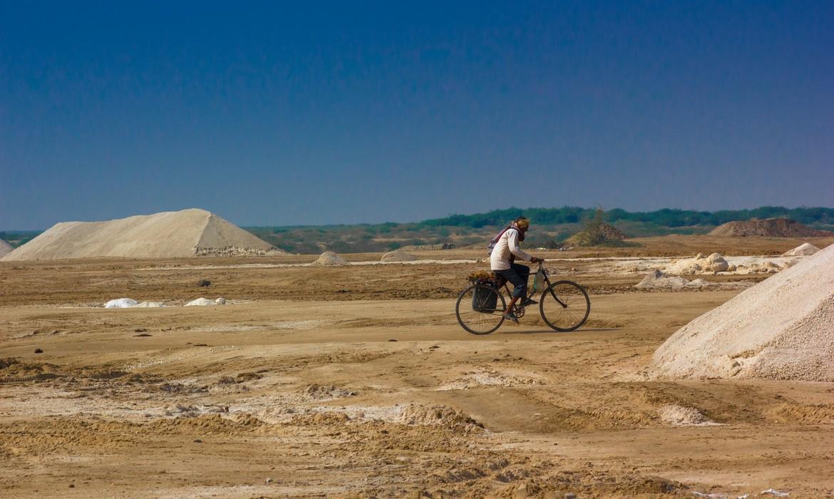 Salt farm worker travelling on bike, Little Rann of Kutch