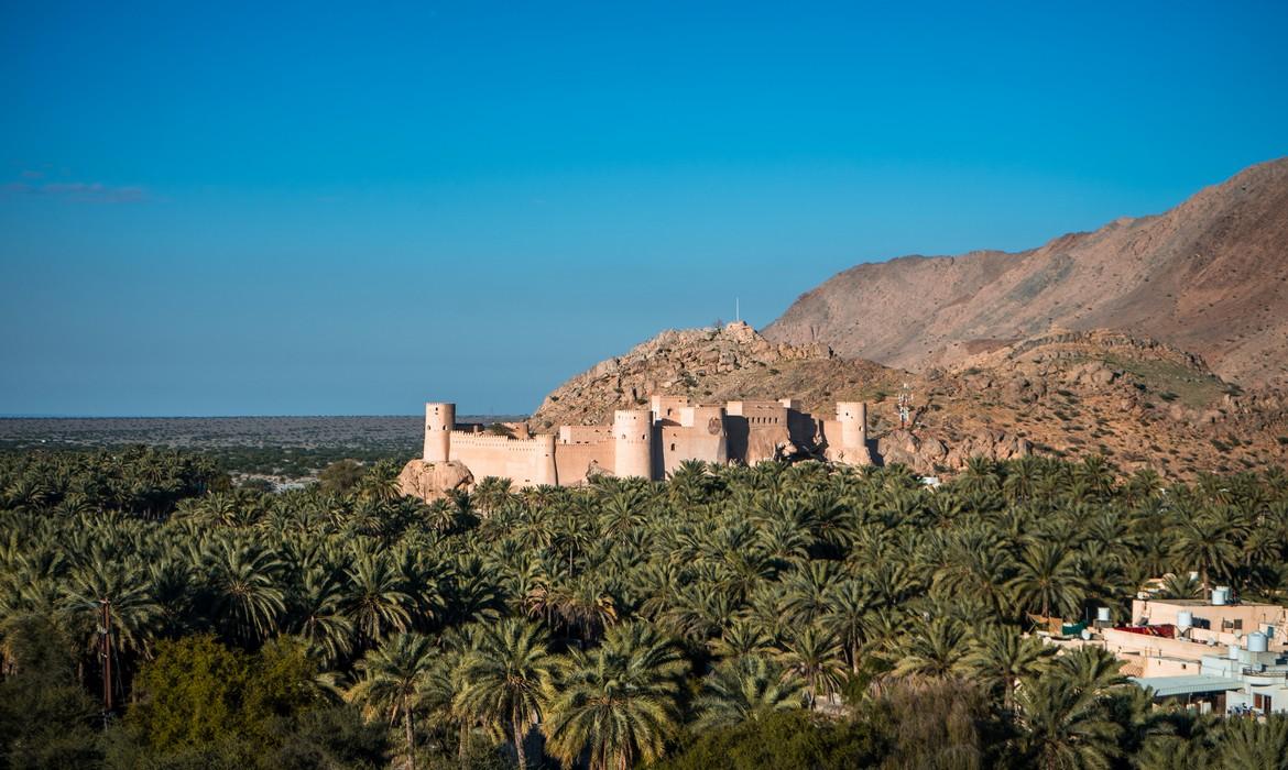 Sunset view of the Nakhal Fort surrounded by a palm grove